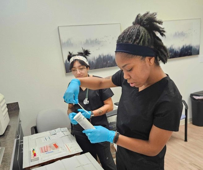 {{ school.name }} students working with medical assisting tools